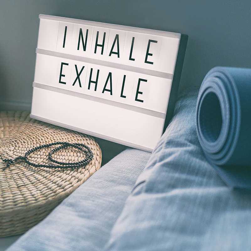 Inhale and exhale next to a yoga mat for therapeutic yoga in South Bend, IN